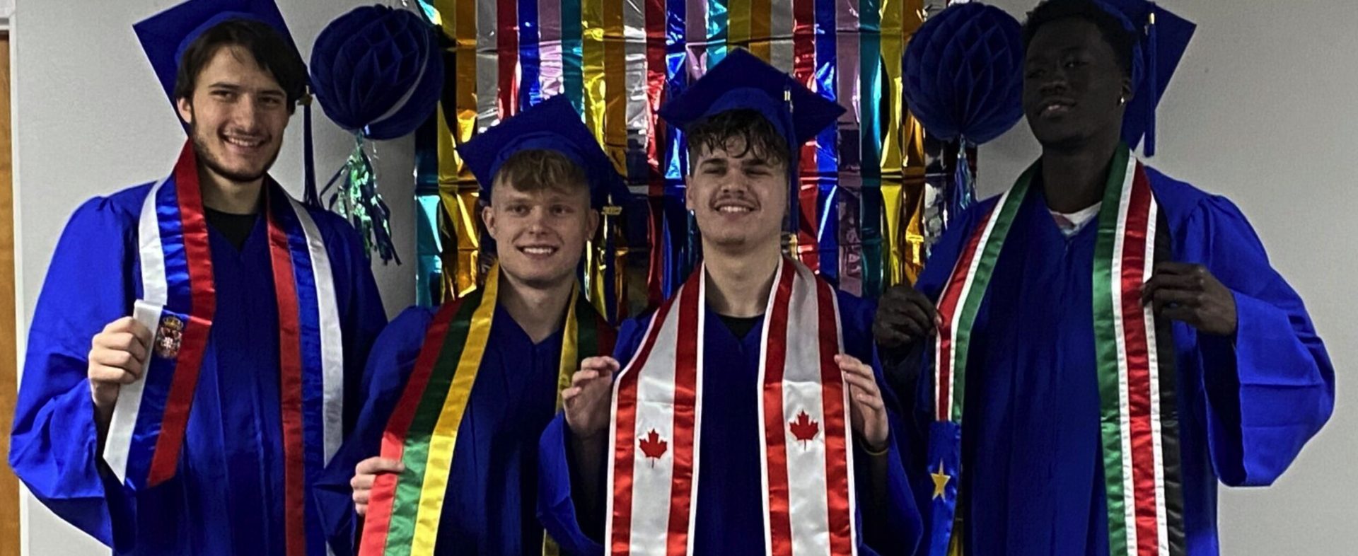Florida Coastal Prep graduates in caps and gowns with international sashes representing students from 43 states and 22 countries